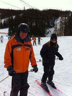 two people on skis standing in the snow