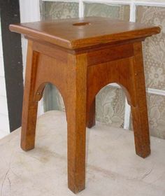 a small wooden stool sitting in front of a window