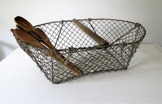 a metal basket with wooden spoons and spatulas in it on a table