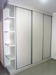 an empty room with white closets and shelves on the wall, in front of a tiled floor