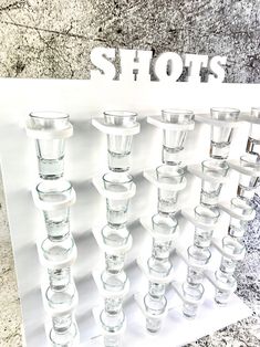 there are many shot glasses lined up on the wall