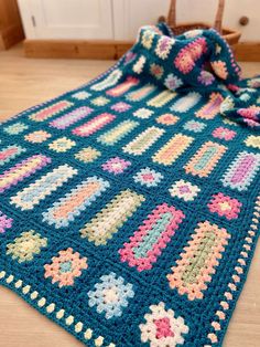 a crocheted blanket is laying on the floor