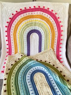 a crocheted blanket with a rainbow design on it
