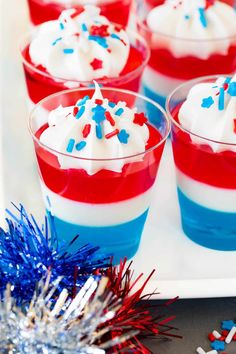 red, white and blue desserts with sprinkles in small cups on a tray