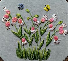 embroidery work with flowers and butterflies on white fabric