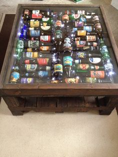 a table made out of beer bottles on top of a carpeted floor with the caption'de estar below it