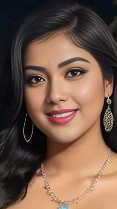 a woman with long black hair wearing earrings and a necklace in front of a dark background