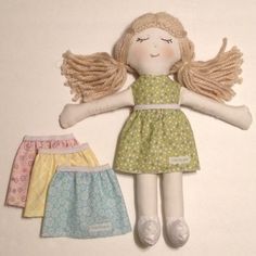 a doll with blonde hair laying on top of it's back next to three other dolls