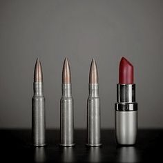 three lipsticks are lined up on a table with one red and the other silver