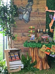 an outdoor dessert table is decorated with fake trees and decorations for the forest themed birthday party