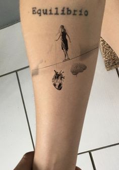 a person with a tattoo on their leg that says baulibirdo and an image of a woman walking across a tightrope