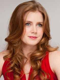 a woman with long red hair wearing a red dress