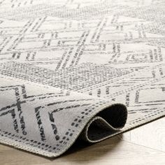 an area rug on the floor with a white and black pattern