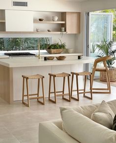 a kitchen with white counter tops and wooden stools