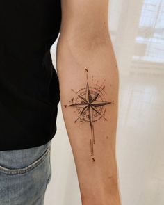 a man with a compass tattoo on his arm