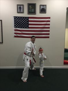 a man and child standing in front of an american flag