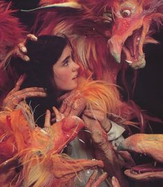 a woman is surrounded by monster hands and other demonic looking creature arms, as she stares into the distance