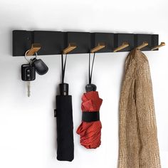 a coat rack with umbrellas and keys hanging on it