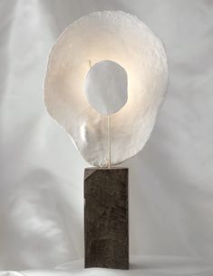 a sculpture with a white circle on top of it