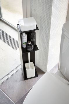 there is a toilet in the bathroom with its lid up and some bottles on it