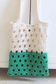 a green and white crocheted bag hanging from a hook on a door handle