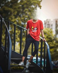 a young man standing on top of a metal hand rail next to a set of stairs