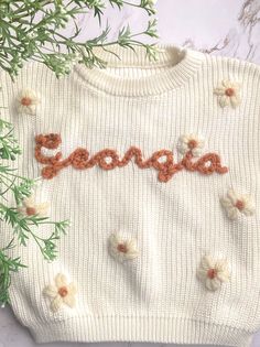 Every babe needs one of these oversized, hand embroidered name sweater. Each one is custom made with desired sweater color, yarn color and selected name. These name sweaters would be great for baby announcements, family pictures, first birthdays or as a gift! Each one is truly one of a kind, being hand embroidered unique to your babe. Available in size 3-6 months to 5T.  Production and shipping can take up to 2 weeks. If the product is needed sooner, please send me a message to see if we can accommodate the need by date. Thanks! Embroidered Name Sweater, Sweater With Name, Baby Name Sweater, Hand Embroidered Name, Name Sweater, Milestone Pictures, Girls Sweater, Embroidered Name