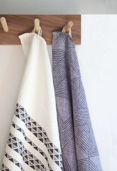 two towels are hanging on a towel rack next to each other, one is blue and the other is white