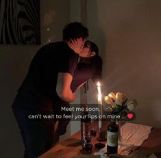 a man and woman kissing in front of a cake with candles on it