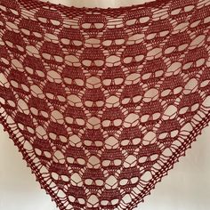 a crocheted shawl is shown with circles on the bottom and sides in red