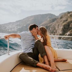 a man and woman kissing on the back of a boat