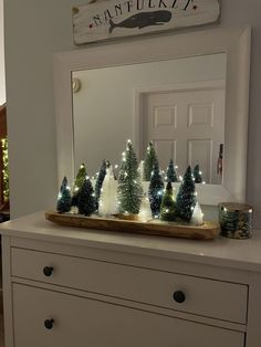 a white dresser with christmas trees on it