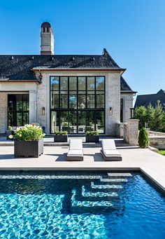 an advertisement for a french style home with a pool and lounge chairs next to it