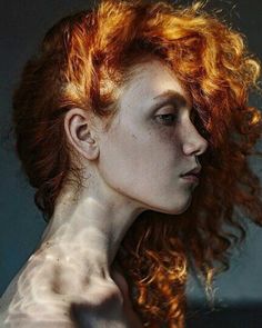 a woman with red hair and freckles on her body is shown from the shoulders down