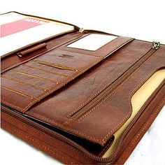 the inside of a brown leather folder with a notepad and pen sticking out of it