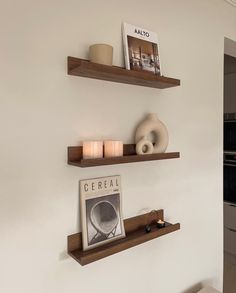 two wooden shelves with candles and pictures on them