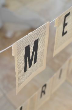 some type of paper hanging from a clothes line with the letter m cut out on it