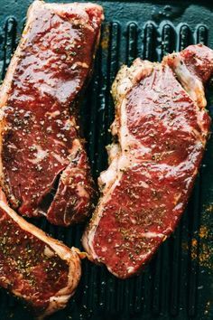 two steaks sitting on top of a grill