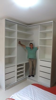 a man is standing in the closet with his hands on the shelves and arms out