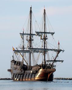 an old sailing ship in the middle of the ocean