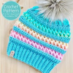 a crocheted hat with a pom - pom sitting on top of it