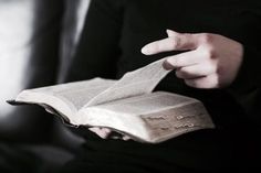 a person holding an open book in their hands