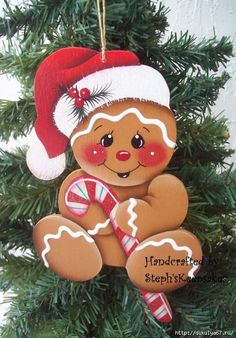 a christmas ornament with a teddy bear holding a candy cane