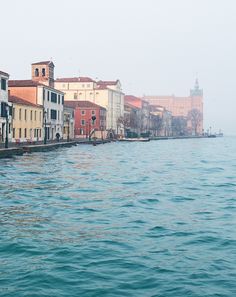 a row of buildings sitting on the side of a body of water