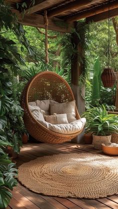 a hanging chair on a porch surrounded by plants