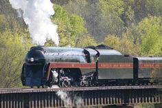 a steam engine train traveling over a bridge