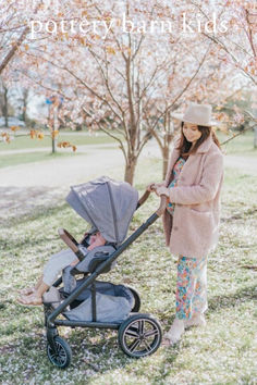 a woman standing next to a baby in a stroller