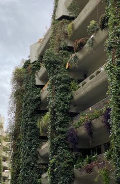 the building has many plants growing on it's sides and balconies above them