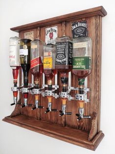 a wooden shelf with several different types of beer glasses on it and bottles in the bottom