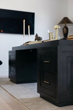 a black desk with candles on it in a living room